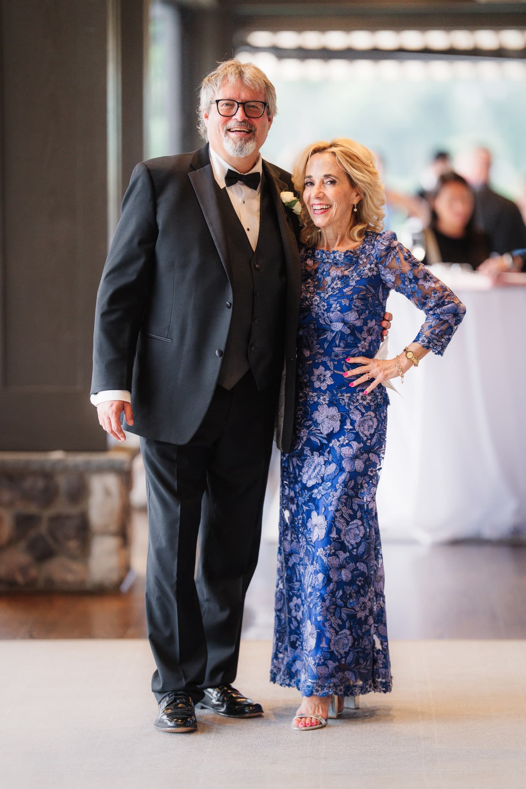 An older couple posing together at the reception, both smiling.