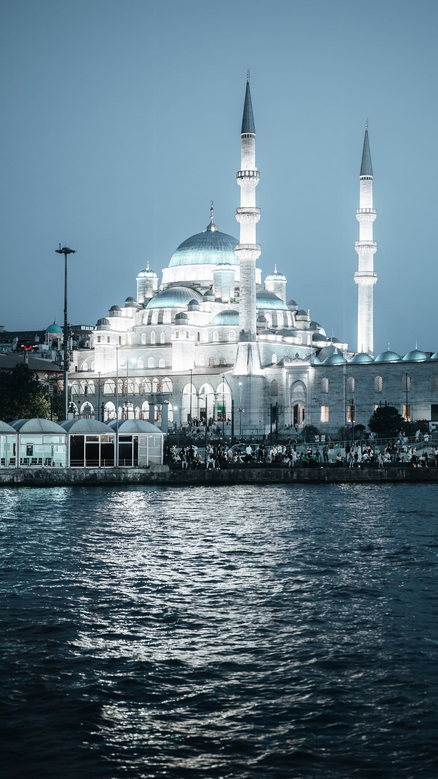 A mosque in Istanbul lit at night, reflected in the water.