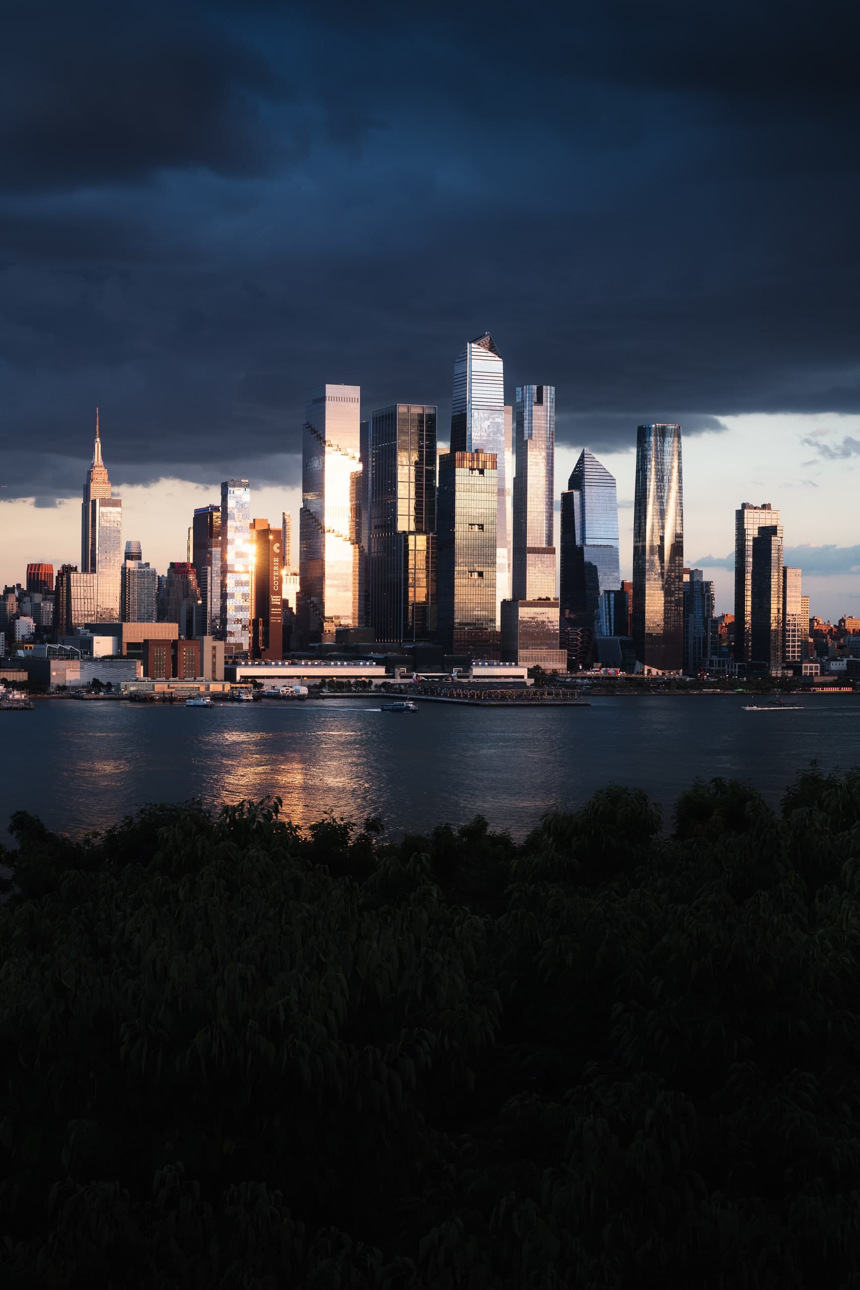 The Manhattan skyline at dusk, seen across the Hudson River, the Empire State Building on the left.