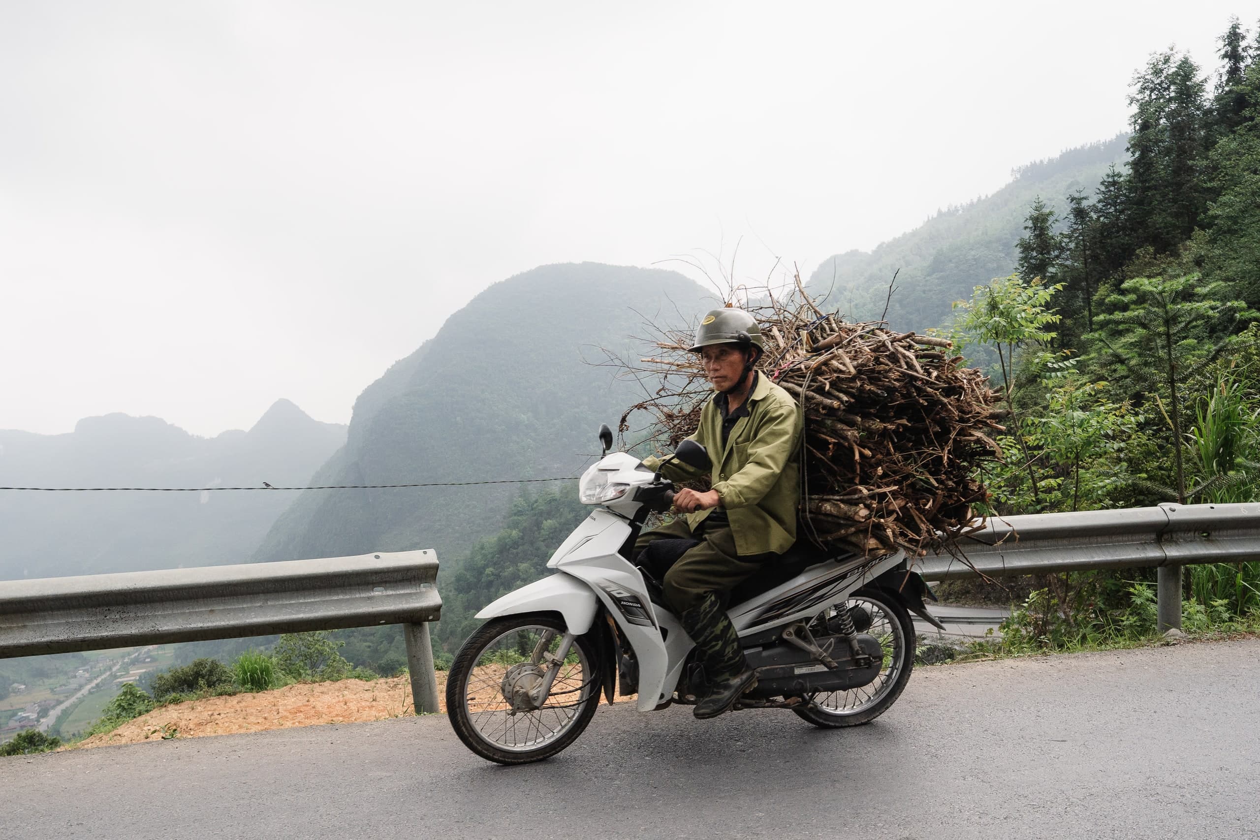 A motorbike loaded with firewood on a mountain road in Vietnam.